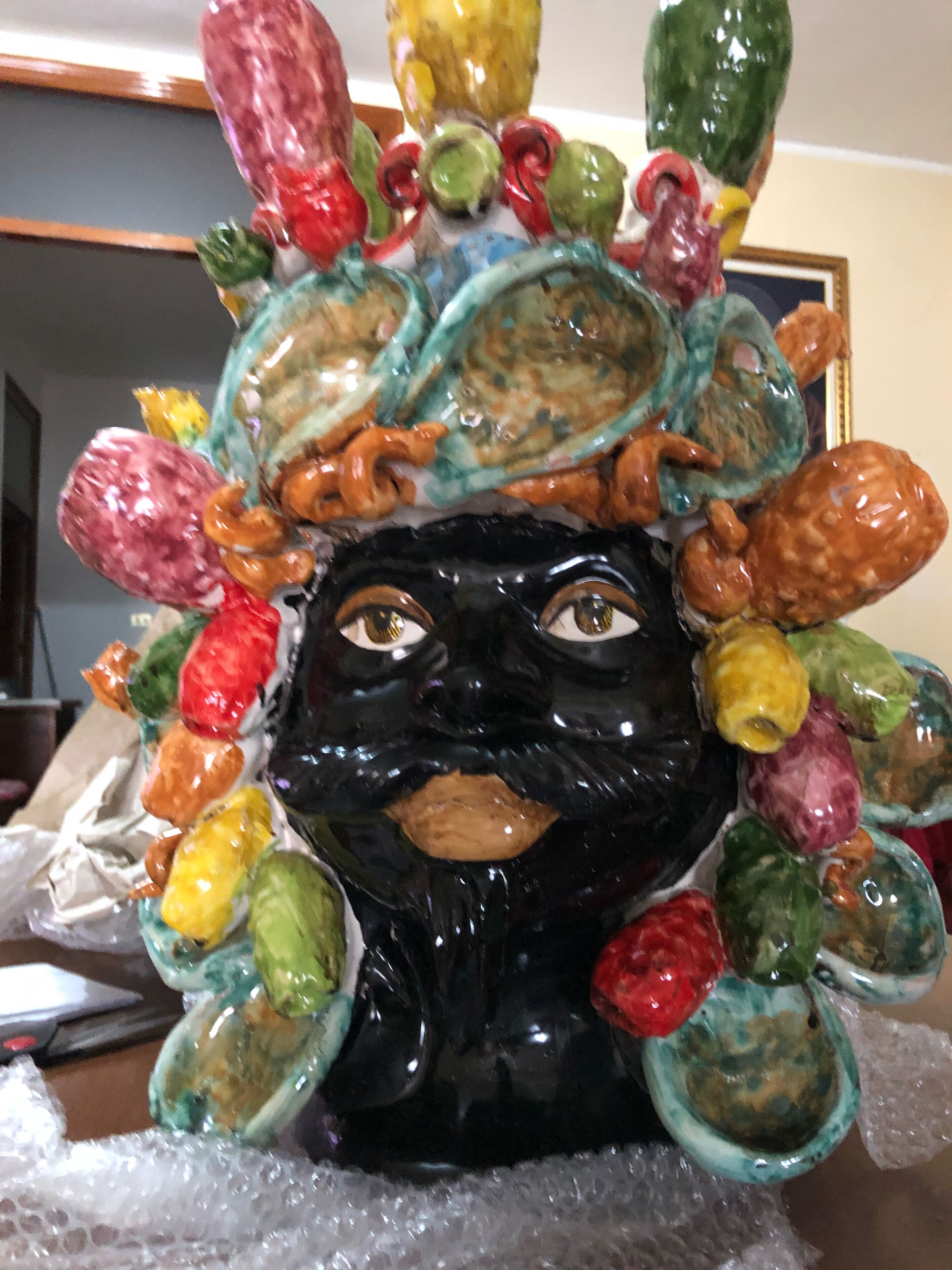 A decorative ceramic sculpture with a black base and colorful elements.