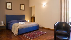 A bedroom with a bed, a chair, a nightstand, and a wall-mounted air conditioner. - Vacation House Zagara - Giardinello (Giardinello)