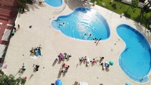 A large outdoor swimming pool with multiple lanes, surrounded by lounge chairs and umbrellas. - 5 minutes from the beach :Apartment Orange Trees panoramic ocean view (Los Cristianos)