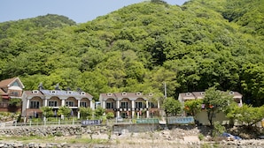 A hotel with multiple buildings, surrounded by lush green hills. - Ulsan Edelweiss Pension (Ulsan)