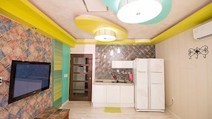 A compact kitchen with a refrigerator, a sink, and a television mounted on the wall. - Ulsan Edelweiss Pension (Ulsan)