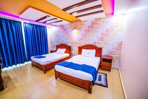 A hotel room with two wooden beds, a stone-patterned wall, and a ceiling with exposed beams and lighting. - Hotel Benco (Kampala)
