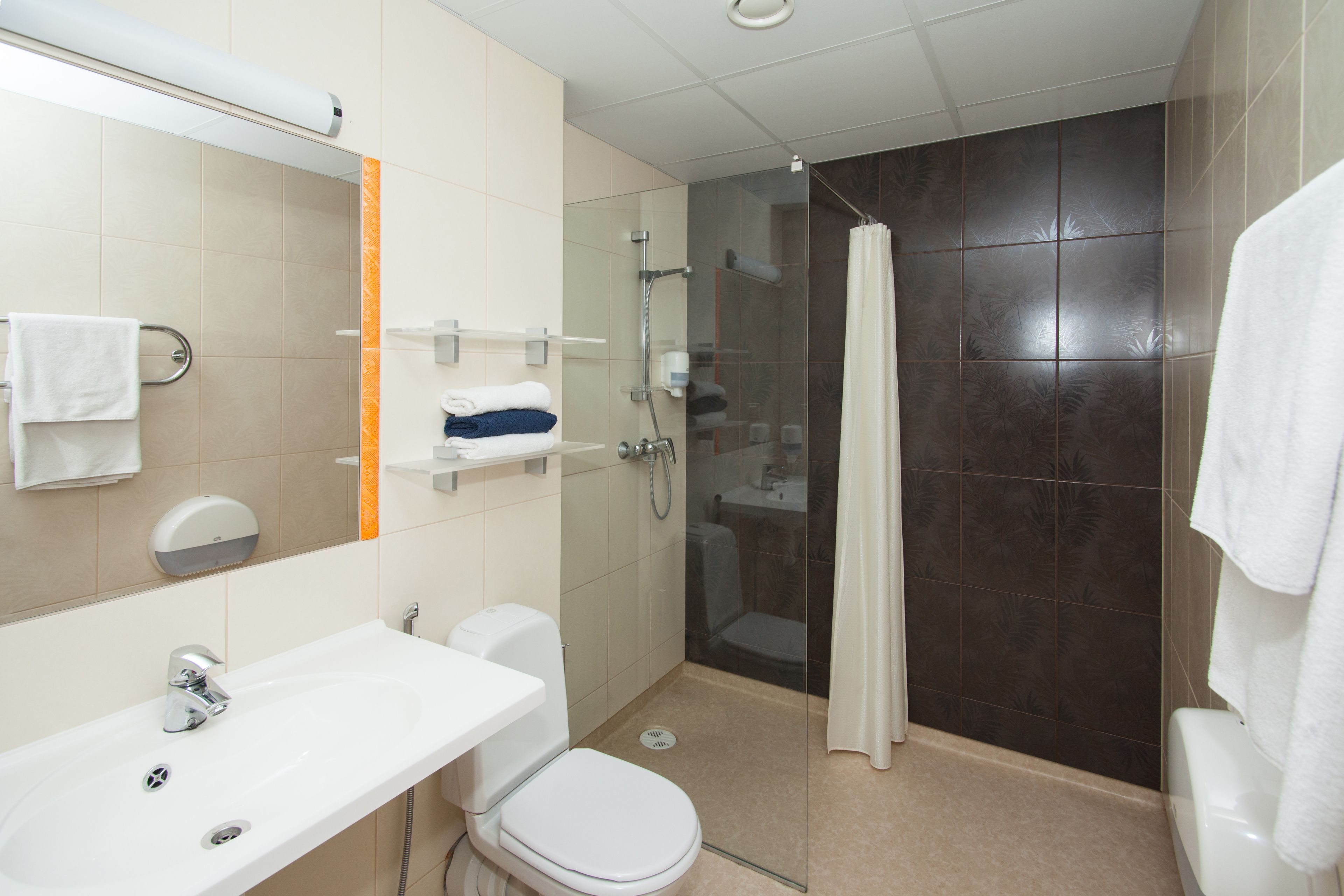 Een moderne badkamer met een witte wastafel, toilet en douchecabine.