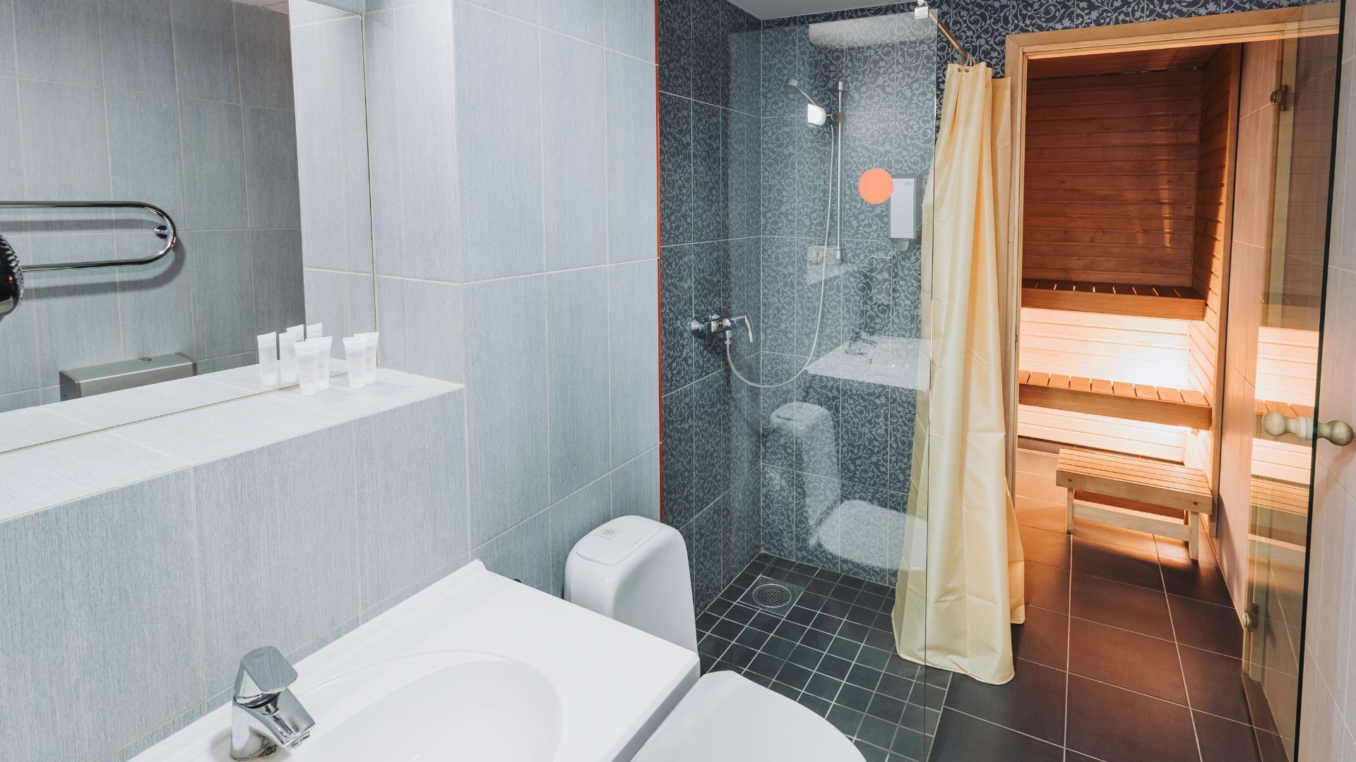 A modern bathroom with a bathtub, shower, and toilet.
