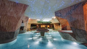 A spacious indoor area with a central water feature, stone walls, and a ceiling with embedded lights. - Viiking Spa Hotel (Parnu)