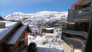 A snowy mountain village with traditional wooden buildings and a modern structure.