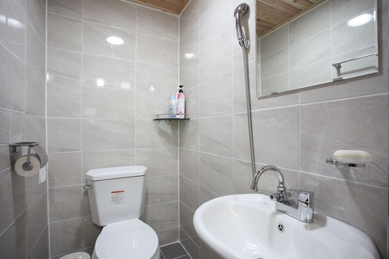 A bathroom with a toilet, sink, and shower.