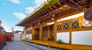 A traditional wooden building with a tiled roof, large windows, and a stone-paved courtyard. - Yewondang (Jeonju)