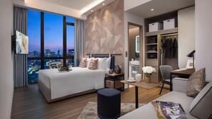 A modern hotel room with a large bed, a sofa, a desk, and a walk-in closet. - Citadines Balestier Singapore (Singapore)