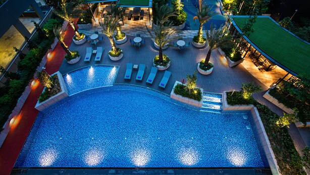 An aerial view of a hotel with a large swimming pool, outdoor seating areas, and landscaped gardens. - Citadines Balestier Singapore (Singapore)