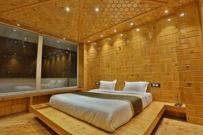A wooden room with a bed, a window, and a wooden wall with a honeycomb pattern.
