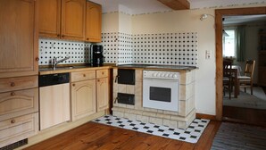 Una cucina con mobili in legno, lavastoviglie, macchina da caffè e forno vintage.