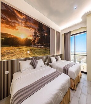 Habitación de hotel con dos camas, un mural panorámico en la pared y vista al mar a través de un ventanal grande.