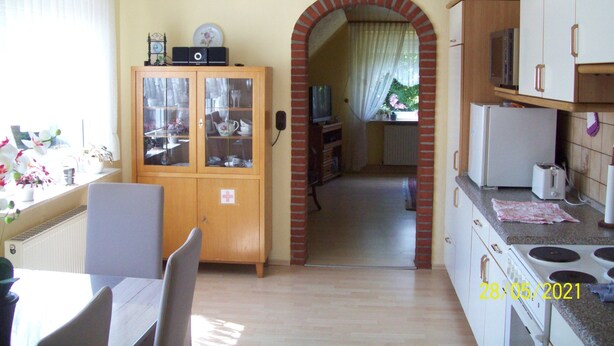 Una cocina con comedor, un arco de ladrillo y vistas al jardín.