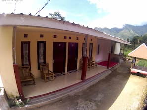 A building with multiple doors, a covered porch, and a red carpet leading to the entrance. - Bale Sembahulun Cottages & Tent (Sembalunbumbung)