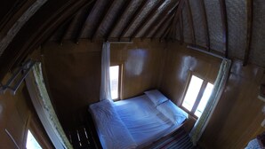 A small, cozy room with a single bed, wooden beams on the ceiling, and two windows providing natural light. - Bale Sembahulun Cottages & Tent (Sembalunbumbung)