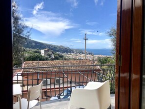 A balcony with a view of a coastal town, including buildings and a mountain in the distance. - On Michele Guest house (Sorrento)