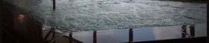 A view of a body of water with waves, a metal railing, and a dark-colored boat or ship. - Nezame Hotel (Agematsu)