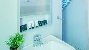 Ein Badezimmer mit einem weißen Waschbecken, einem Spiegel und einem Handtuchhalter.