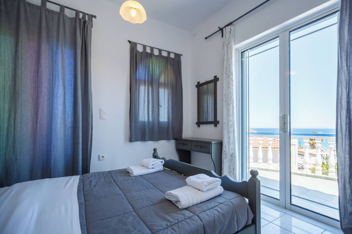 Una camera da letto con un letto, una scrivania e vista sul mare.