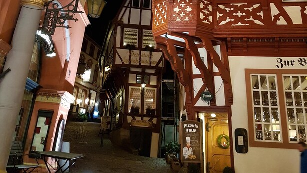 Ein traditionelles Fachwerkhäuschen mit einem Schild für 'Pizzeria Italia' und einer Europafahne.