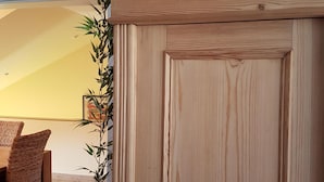 Eine Holztür mit einem dekorativen Oberteil, das Figuren und einen herzförmigen Gegenstand beherbergt.
