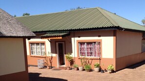 A single-story building with a green roof and a paved driveway. - Standard Way Lodge (Livingstone)