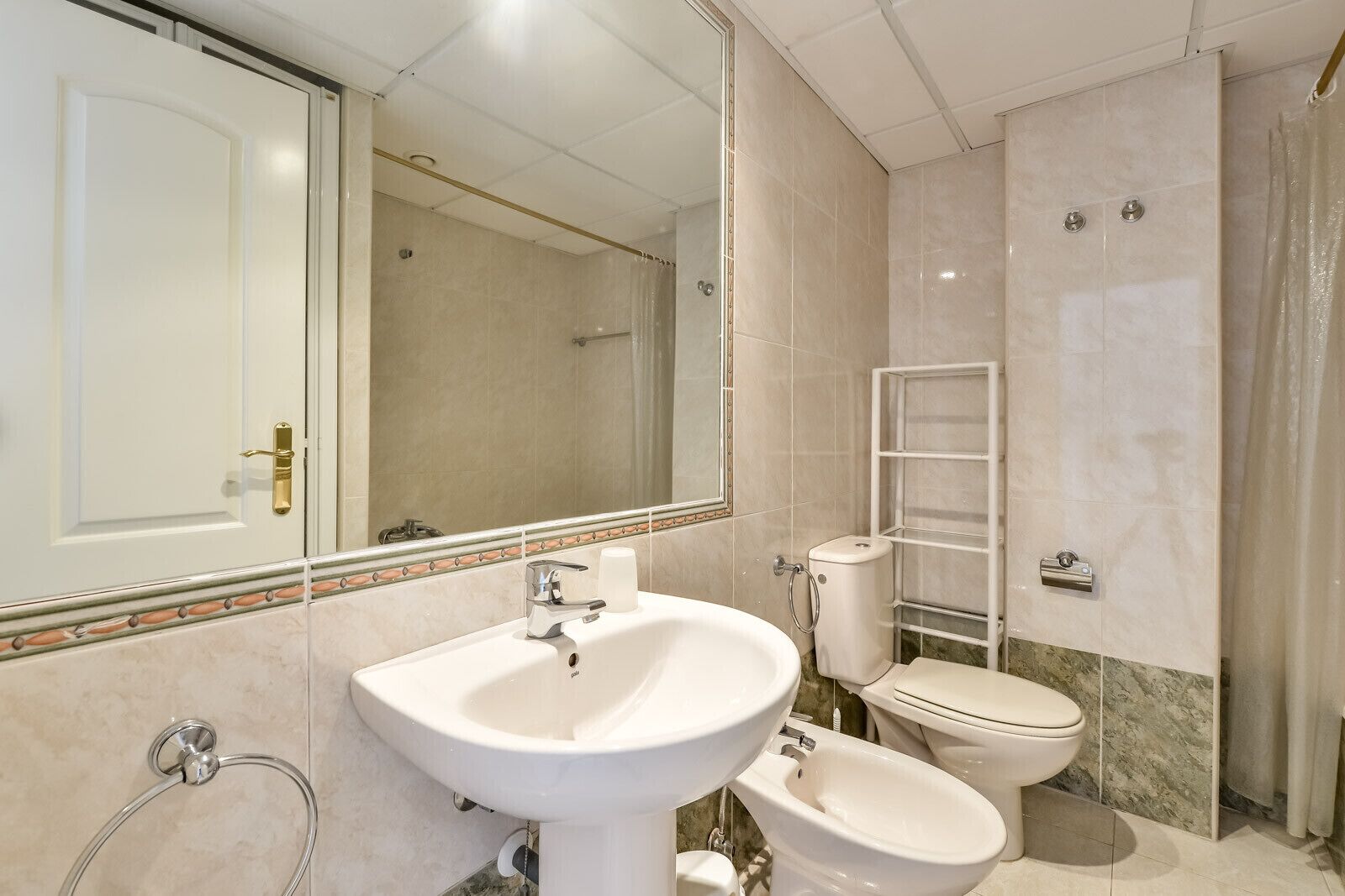 Une salle de bain équipée d’un lavabo, de toilettes, d’un bidet et d’une douche.