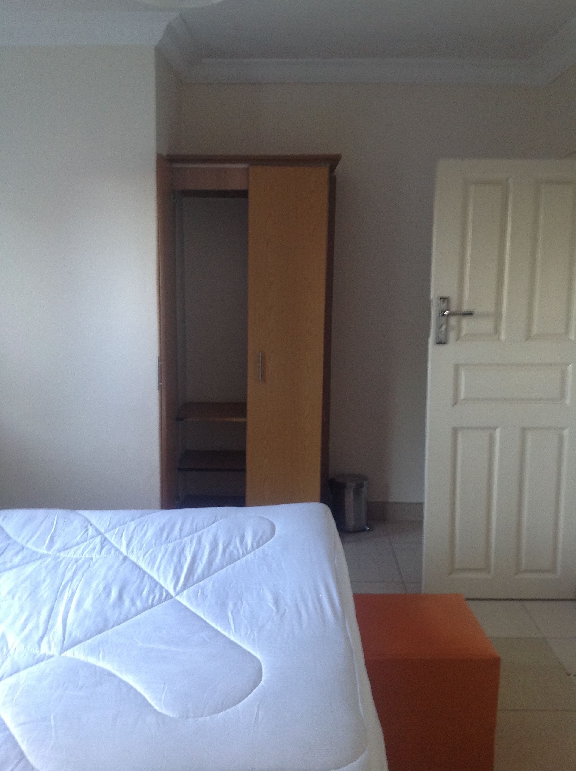 Una camera da letto con un letto, un armadio e una porta.