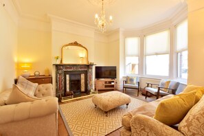 A living room with a fireplace, a television, and a large window. - Belle Vue (Ramsgate)