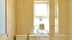 Un baño con inodoro, lavamanos y bañera.