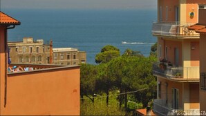 A coastal view with buildings and a boat on the water. - Marino Suite Sorrento (Sorrento)