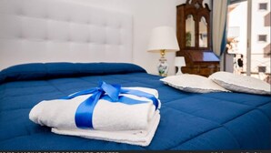 A neatly made bed with blue bedding, a white pillow, and a blue and white towel. - Marino Suite Sorrento (Sorrento)
