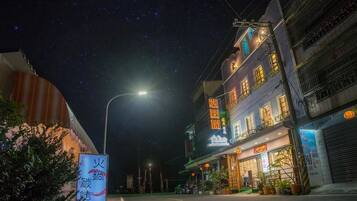 A street at night with a restaurant on the right.