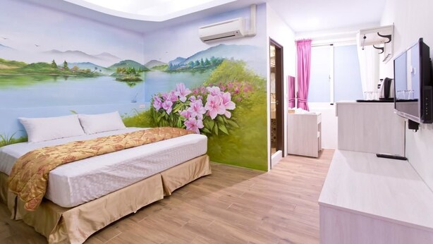 Un dormitorio con cama, escritorio y televisor.