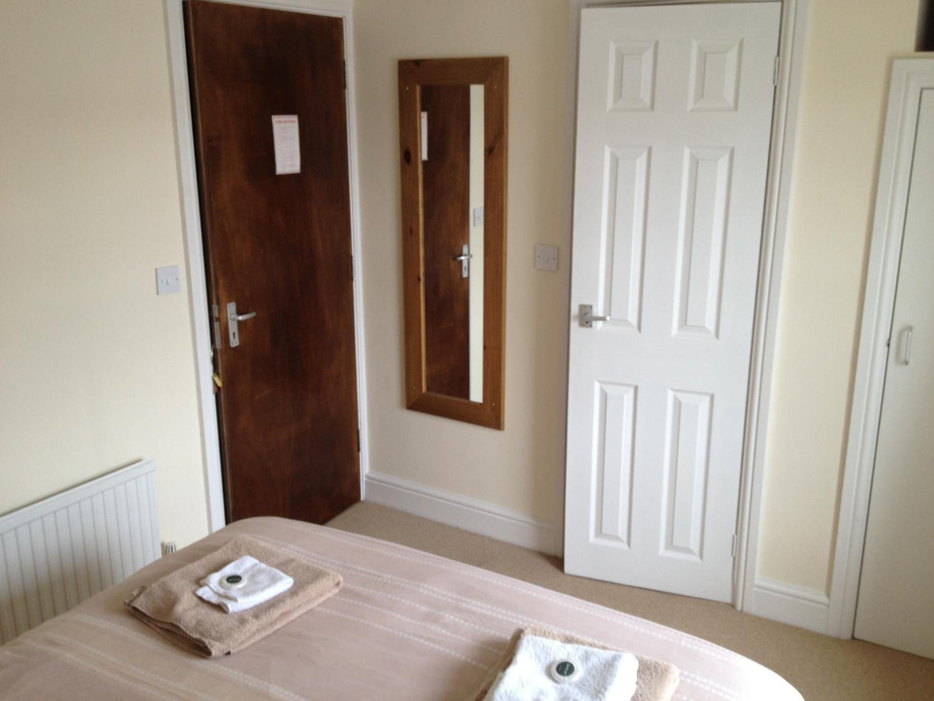 A room with a bed, two doors, and a radiator.