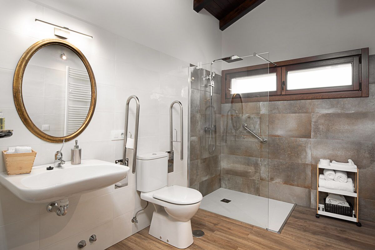 Een moderne badkamer met een wastafel, toilet en een ruime douche.