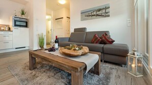 Una sala de estar moderna con una mesa de centro de madera, sofá gris y un cuadro en la pared.