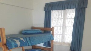 A room with bunk beds, a couch, and a window with curtains. - Beach Mansion 1 (Margate)