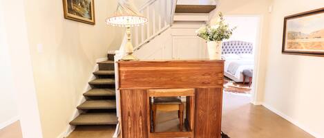 A staircase with a wooden finish, a small wooden table with a lamp, and a cowhide rug on the floor.