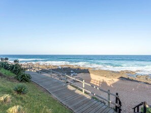 En la playa, arena blanca, sillas reclinables de playa, sombrillas