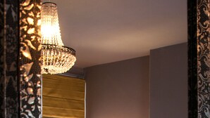 A hotel room with a large mirror, a bed with blue bedding, a bedside lamp, and a window with blinds. - Aldersyde Bed and Breakfast (Whitby)