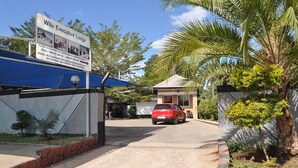 A sign for Wilu Executive Lodge with contact details and amenities listed. - Willu Executive Lodge (Livingstone)