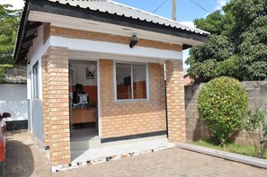 A small, single-story building with a brick facade, a tiled entrance, and a small window. - Willu Executive Lodge (Livingstone)