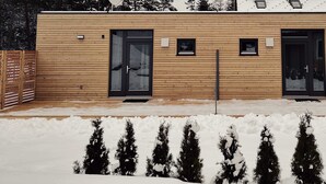 A modern wooden cabin with two black doors, a small window, and a metal doorbell. - Apartment 1 - FREE Ride cabins (Tösens)