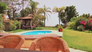 A backyard with a swimming pool, wicker furniture, and a gazebo. - Vacation home with pool in a beautiful country location with sea views Wifi included (Santa Cruz de Tenerife)