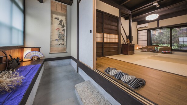 Ett traditionellt japanskt rum med tatamimattor på golvet, skjutdörrar och utsikt över omgivningen.