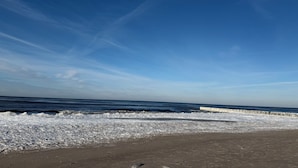 Una playa con arena y una barrera blanca.