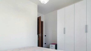 Ein Schlafzimmer mit einem Bett, einem Kleiderschrank und einem kleinen Nachttisch.