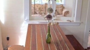 Un tavolo di legno con un vaso di fiori secchi.